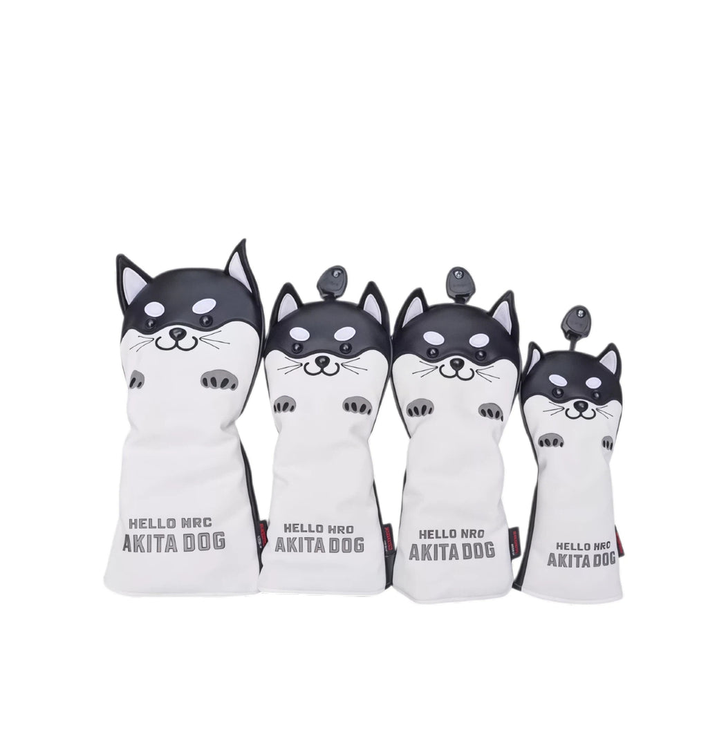 Front view of a four-piece black and white Akita Inu golf headcover set featuring cartoon-style dog faces with expressive eyes and paws, labeled "HELLO NRC AKITA DOG" — ideal for driver, fairway, hybrid, and utility clubs.