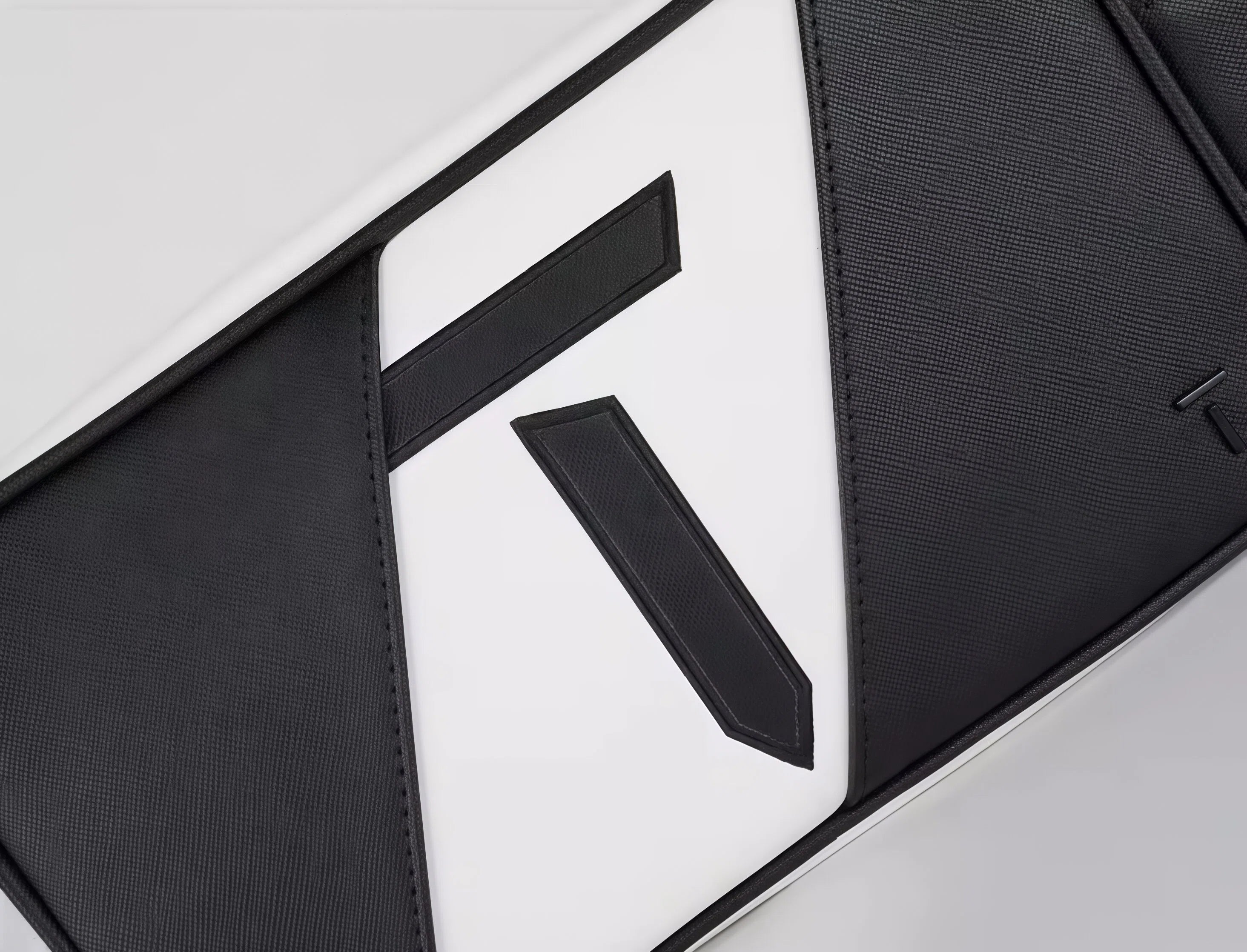 High-resolution close-up of the European Tour golf pouch highlighting the textured stitching and layered design of the "T" logo. Crafted with precision and premium materials.