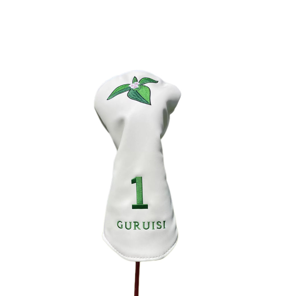 Close-up of GURUISI white driver headcover with embroidered leaf and flower pattern — features large number "1" and brand name "GURUISI" in green thread for easy identification and elegant look.