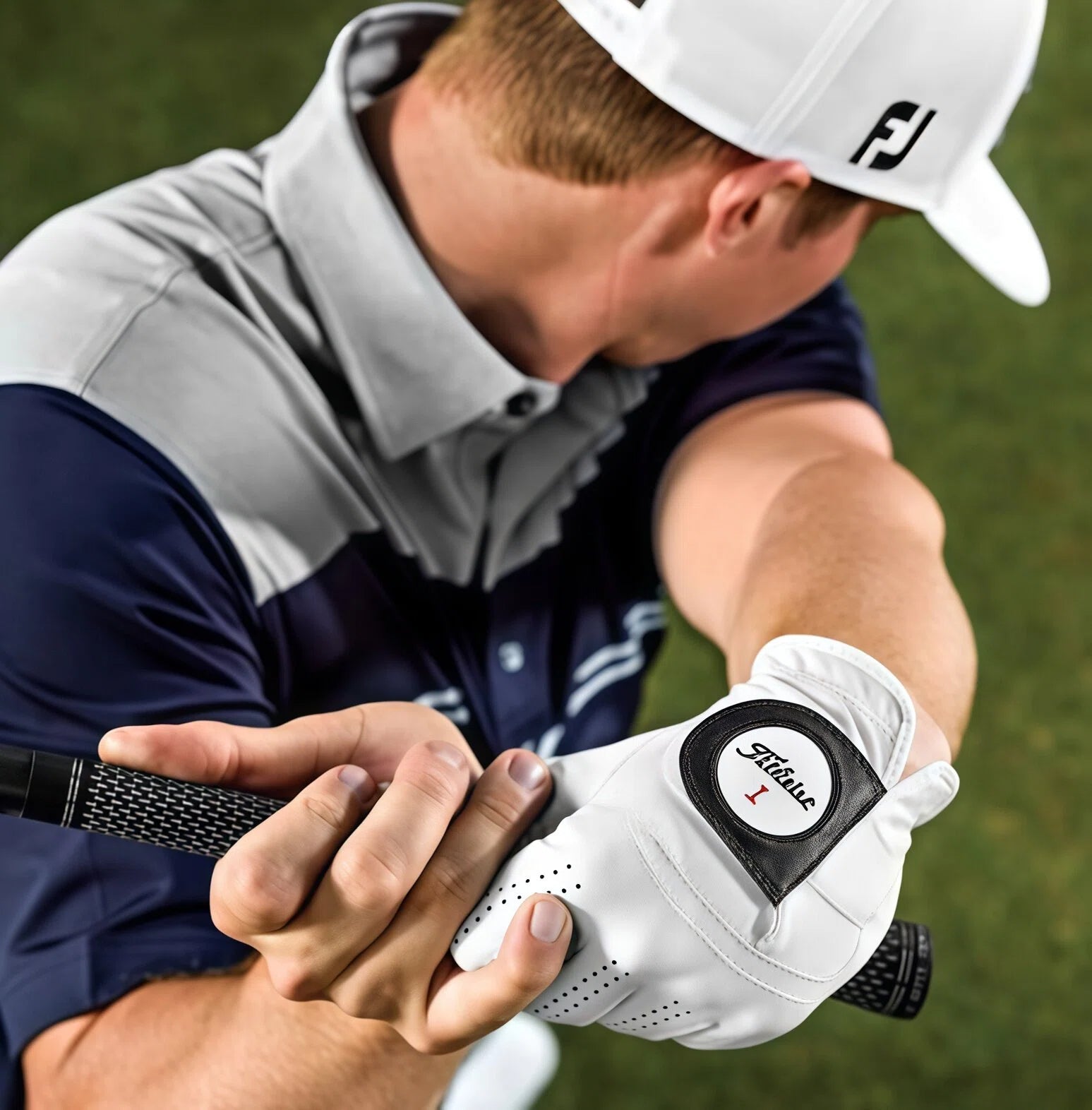 Male golfer wearing a white Titleist Perma-Soft left-hand glove gripping a golf club, demonstrating the glove's superior fit, comfort, and non-slip performance on the course.