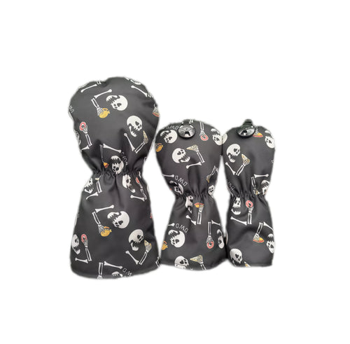 Back view of black graffiti flocked golf headcovers set showing elastic hem, metal snap button and repeating skull and bone print, compatible with driver, fairway and utility clubs for secure fit.
