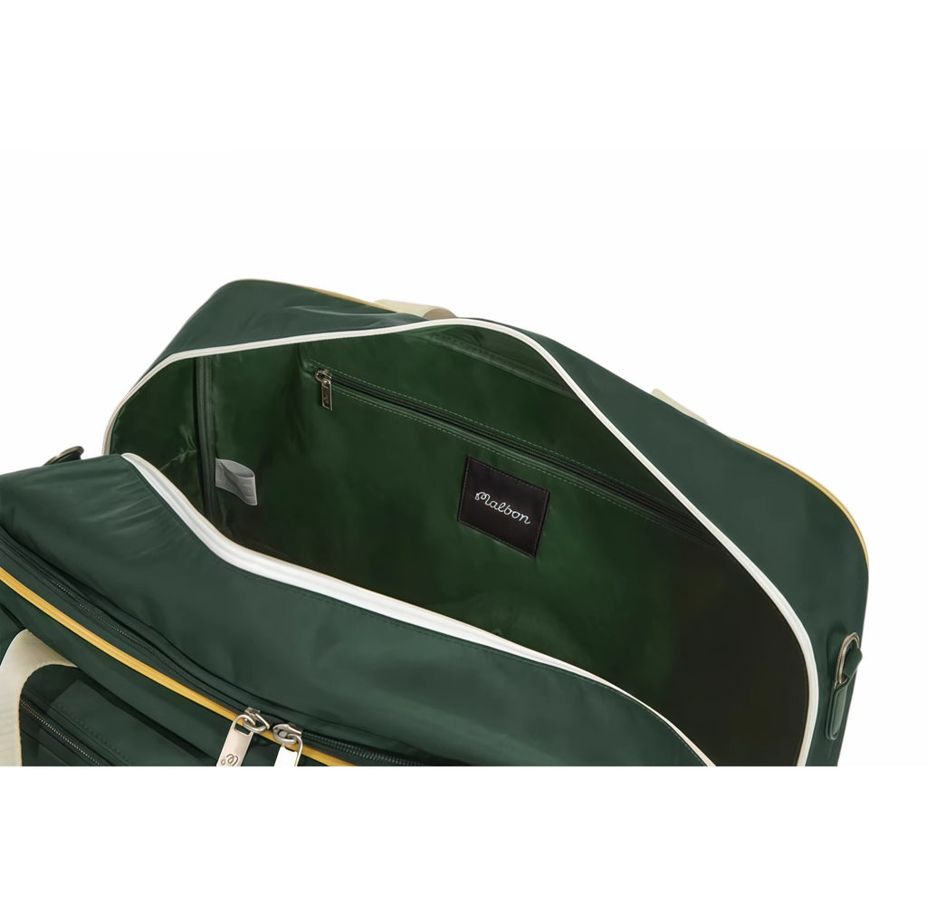 Front view of green Malbon golf duffle bag featuring multiple zippered pockets, beige handles, yellow trim, "Malbon" embroidered logo, and cartoon golf ball character wearing a hat