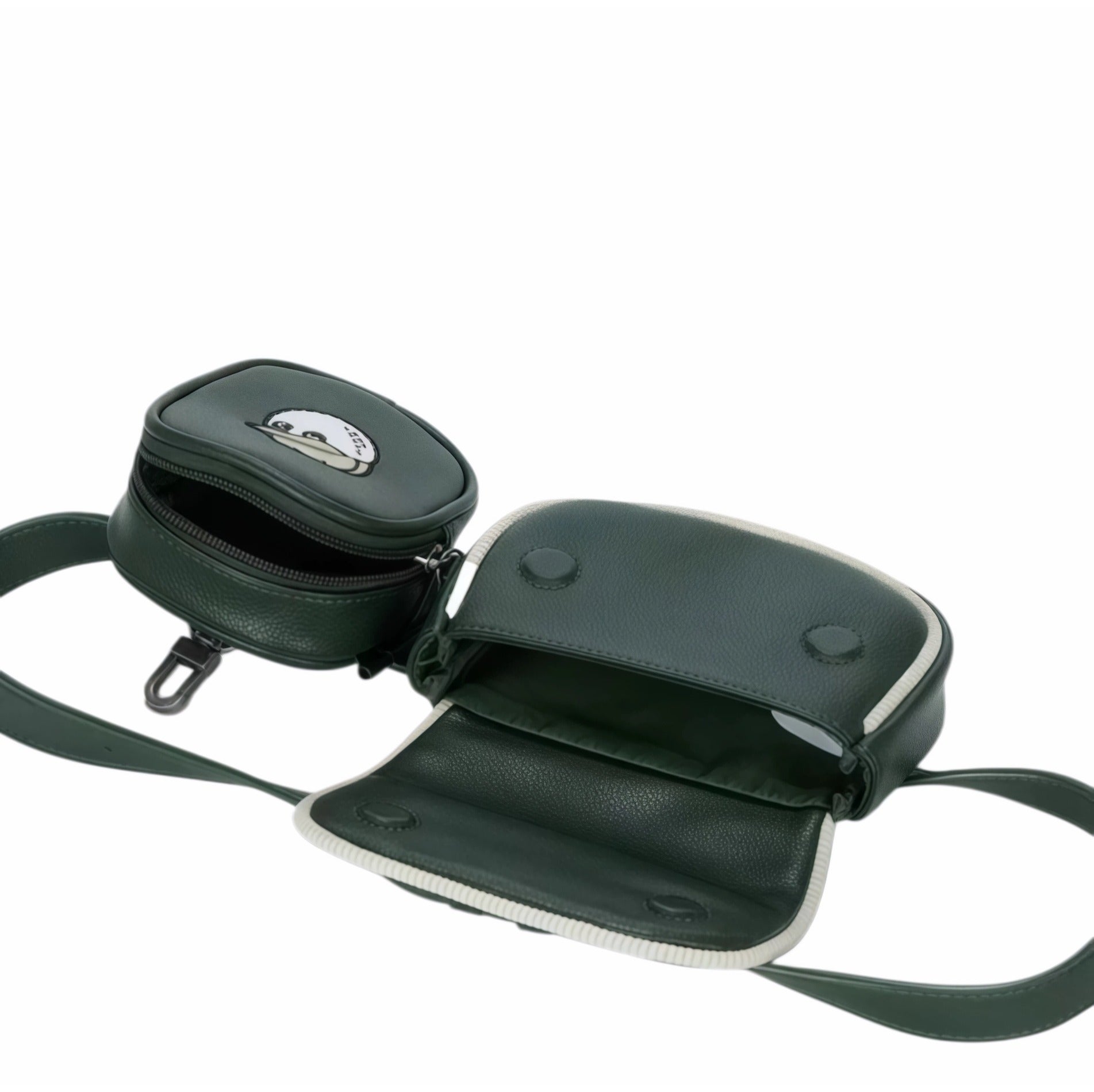 Open view of Malbon Golf dual pouch belt bag in forest green displaying internal space, black lining, stitched edges, and cartoon golf ball mascot on front pocket