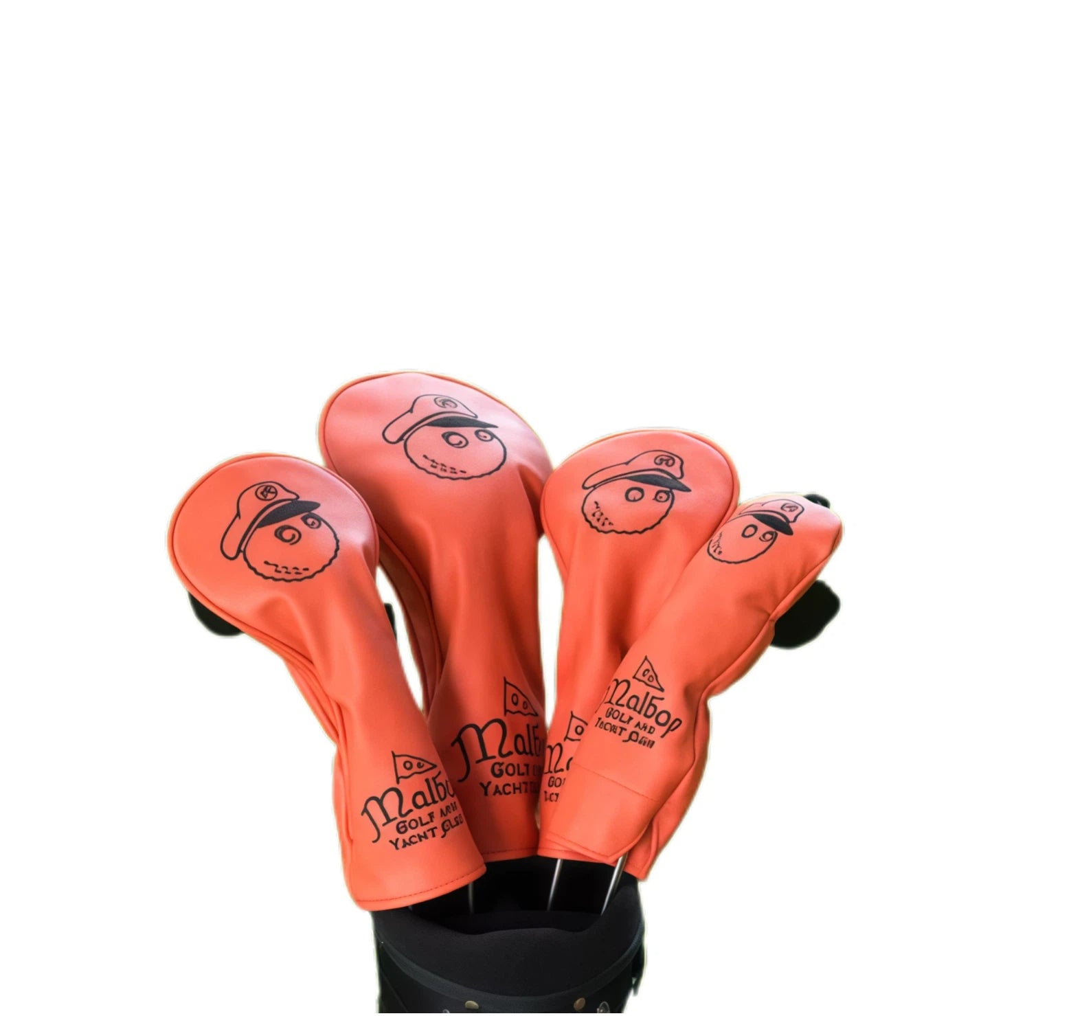 Coral orange Malbon golf headcovers with black outlined cartoon captain graphic and brand text, shown protecting drivers and fairway woods inside a golf bag.