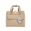 Beige Malbon golf tote bag featuring white embroidered "Malbon Golf" script, front flap design, and cute golf ball-shaped charm hanging from the handle