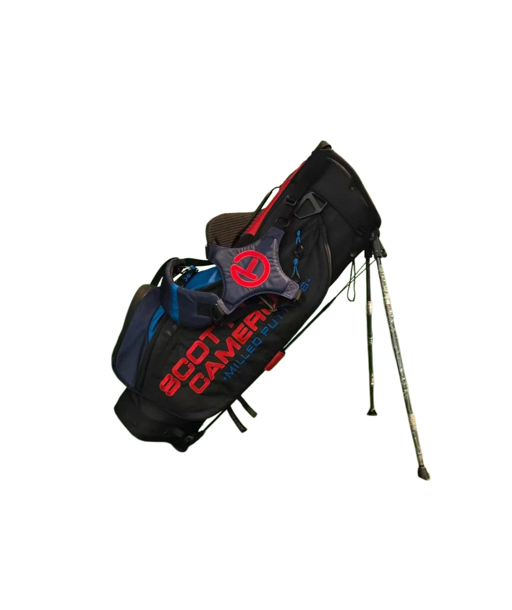 Scotty Cameron Pathfinder Stand Bag in deployed position with extended legs, showcasing the Black/Red/Blue colorway, Circle T branding, and stable stand mechanism for on-course use.