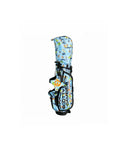 Top-down perspective of the Scotty Cameron Pathfinder Surfer-Blue bag, revealing the patterned fabric with surfers and waves, black trim accents, and the iconic orange Circle T emblem on the front pocket.